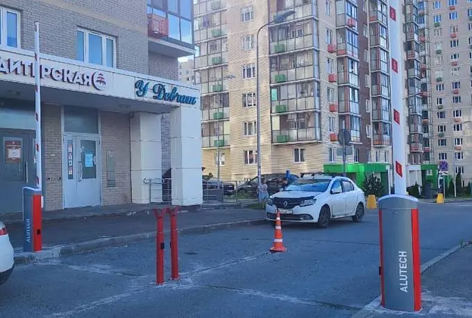 Красно-белые шлагбаумы у въезда во двор жилого дома